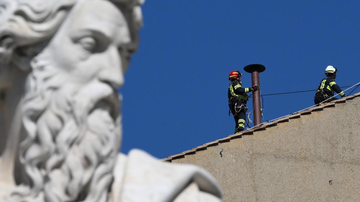 Los bomberos instalan la chimenea en el techo de la Capilla Sixtina.