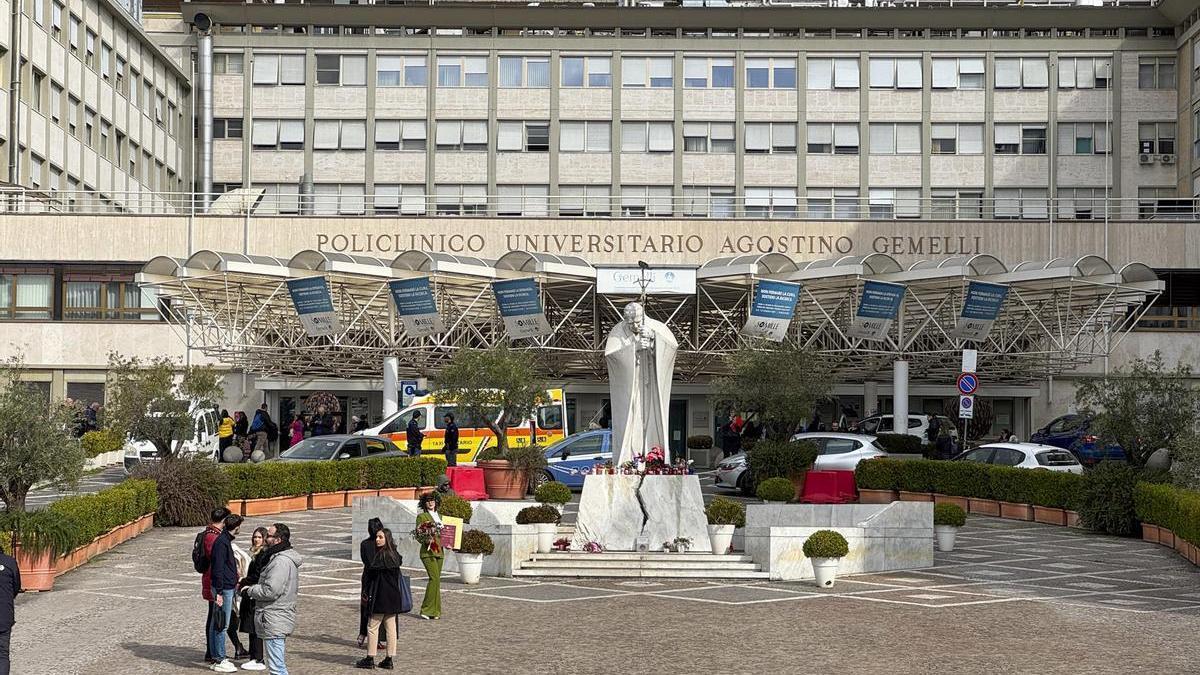 Velas y flores a los pies de la escultura de Juan Pablo II a las puertas del Hospital Gemelli de Roma.