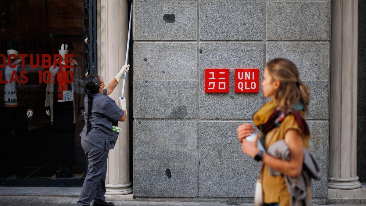 Una mujer limpia la fachada de un edificio.