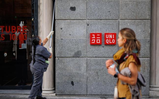 Una mujer limpia la fachada de un edificio.