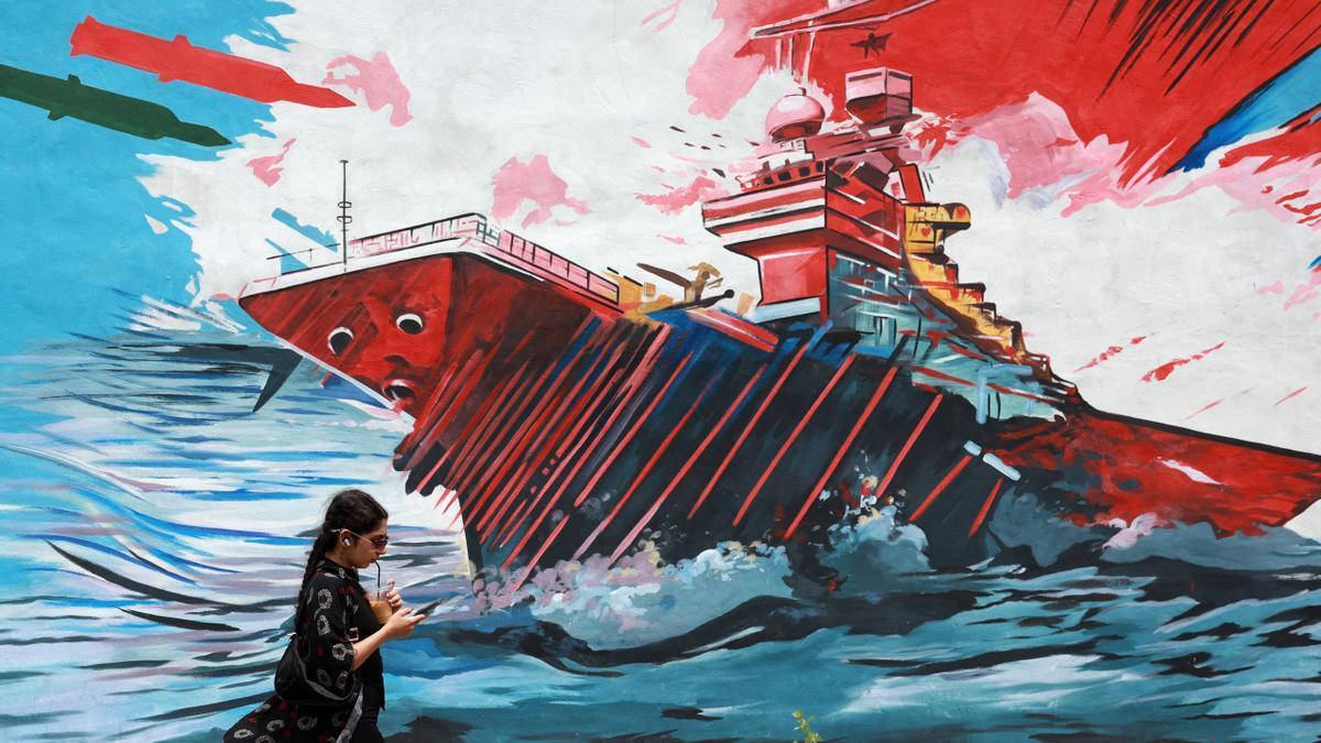 Iraníes caminan junto a un mural contra EE.UU. en Teherán.
