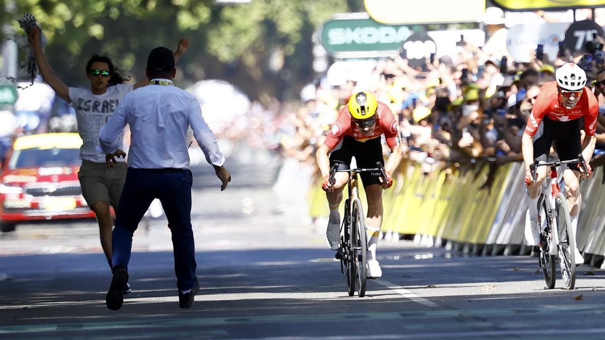 Un espectador, en contra de la participación de Israel en el Tour, protesta en la llegada donde Abrahamsen puede con Schmid.