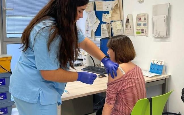 Una enfermera vacuna a una mujer en un ambulatorio.