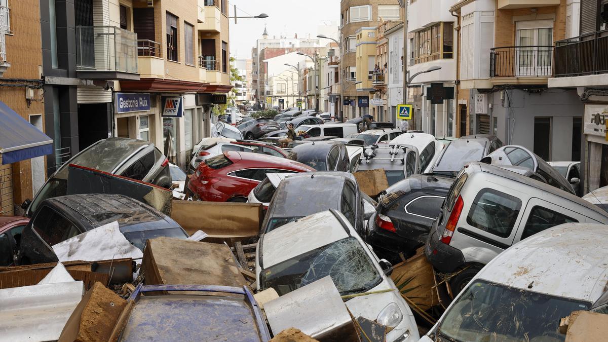 Vehículos amontonados en una calle tras las intensas lluvias en Valencia.