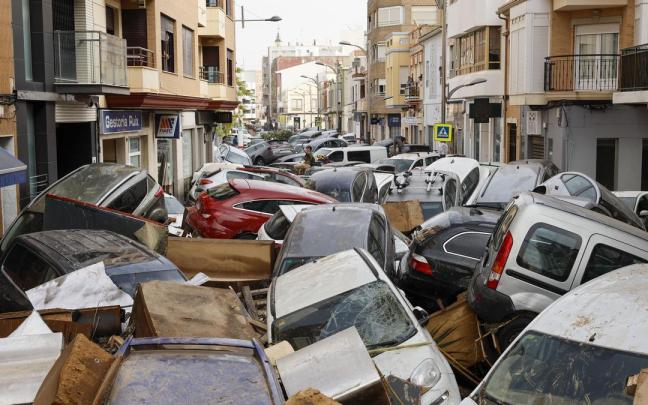 Vehículos amontonados en una calle tras las intensas lluvias en Valencia.