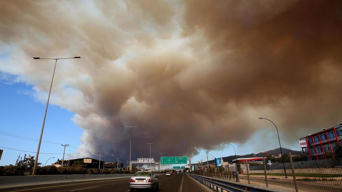 n humo espeso cubre la carretera nacional en Atenas debido a un incendio forestal que estalló en una zona agrícola en Varnavas.