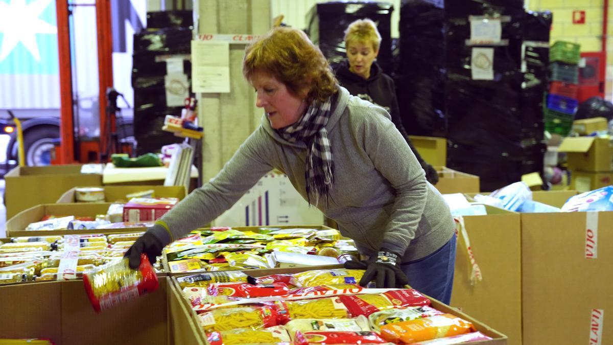 Una mujer organiza en cajas comida para mandar a los afectados por un terremoto