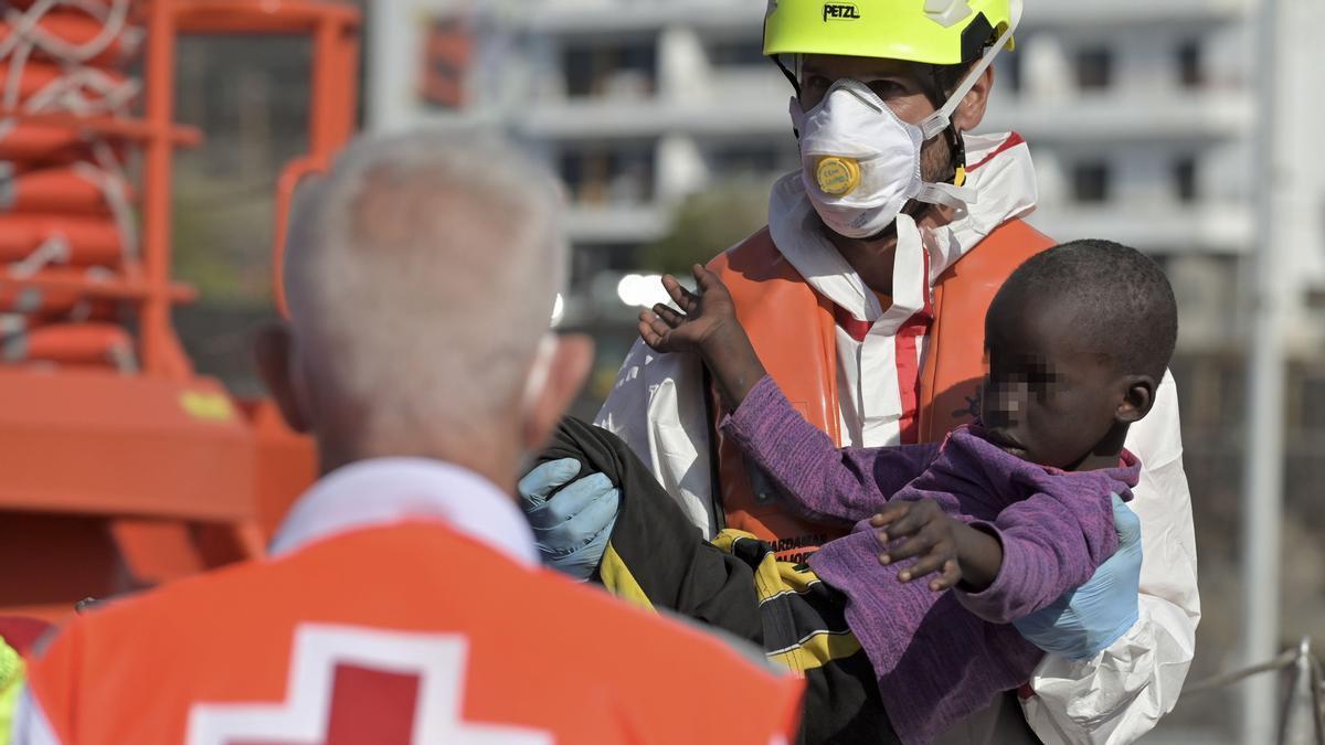 Un miembro de Salvamento Marítimo atiende a un menor rescatado de un cayuco en El Hierro.