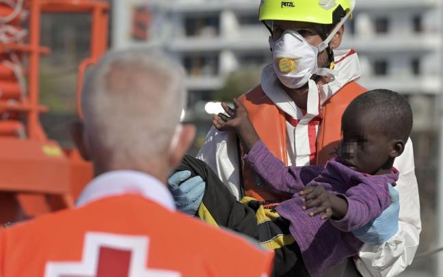 Un miembro de Salvamento Marítimo atiende a un menor rescatado de un cayuco en El Hierro.