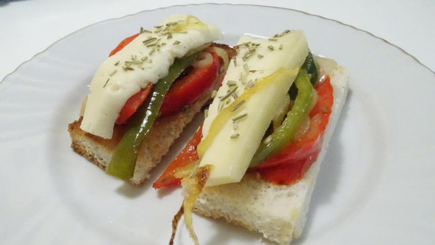 Dos canapés de pimiento, cebolla y queso de tetilla.