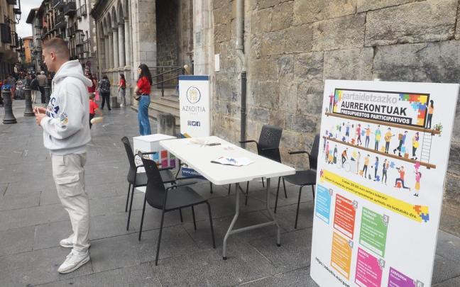 Mesa informativa sobre los presupuestos participativos instalada junto a la parroquia de Azkoitia
