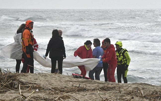 Miembros de Cruz Roja y del servicio de bomberos trasladan los cuerpos de los migrantes fallecidos cerca de las costas de Calabria. Miembros de Cruz Roja y del servicio de bomberos trasladan los cuerpos de los migrantes fallecidos cerca de las costas de Calabria.
