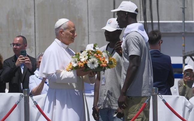 El Papa, junto a dos jóvenes migrantes, antes de arrojar un ramo de flores a las aguas del puerto canario de Arguineguín.