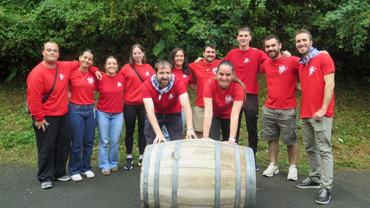 Varios miembros de la comisión de fiestas, con una de las barricas que se utilizará el domingo.
