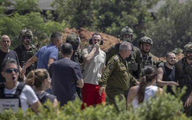 Tres de los rehenes liberados, a la izquierda con camiseta negra, en el centro con camiseta blanca y a la derecha con camiseta de tirantes.