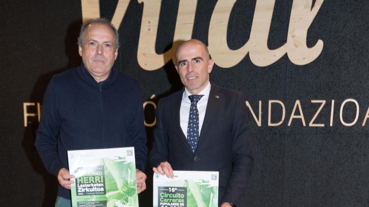 Mikel García y Axier Urrresti posan con el cartel del Circuito de Carreras Populares de Álava