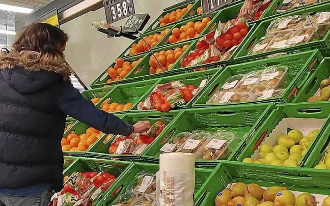 Una mujer compra fruta en una gran superficie vasca.