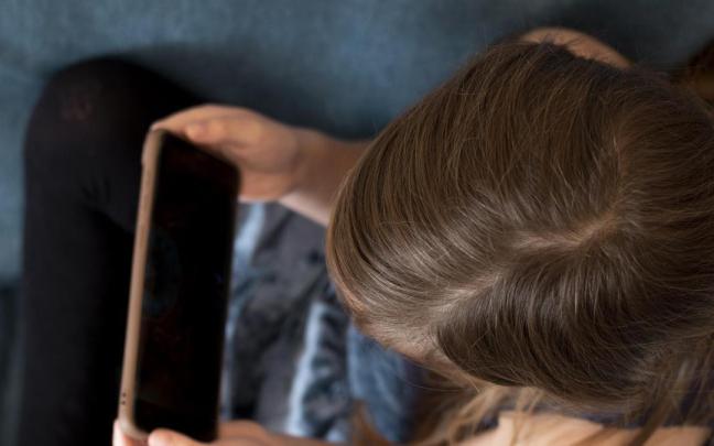 Imagen de archivo de una niña con un móvil.