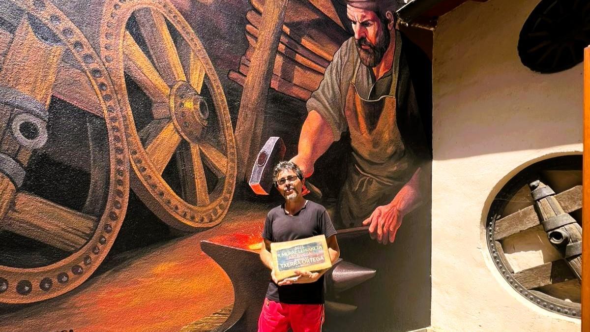 Cherra Ortega posando con su premio junto al mural homenaje a La Fragua