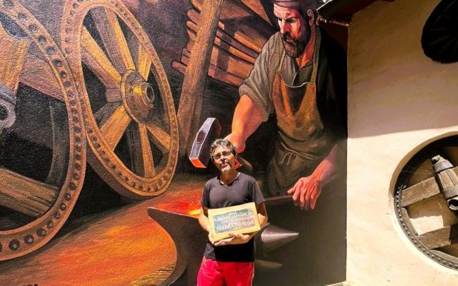 Cherra Ortega posando con su premio junto al mural homenaje a La Fragua