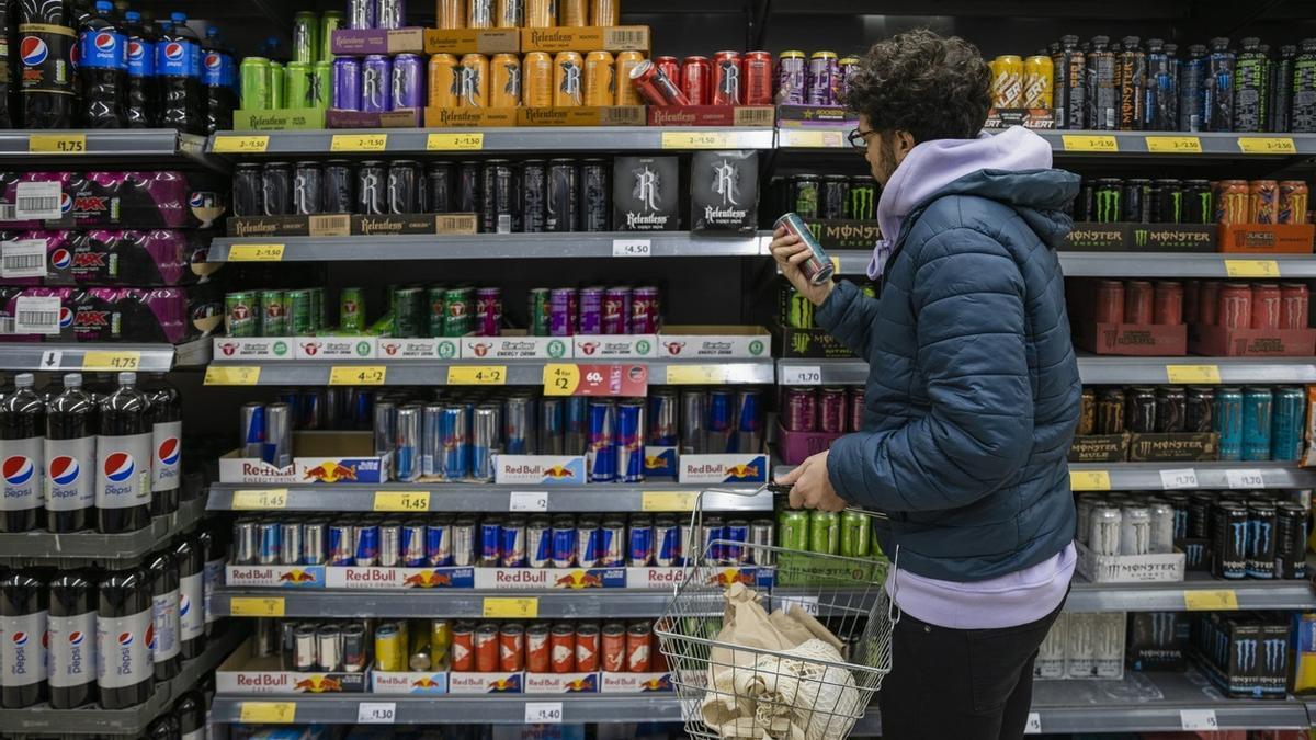 Un joven observa una lata de una bebida energética