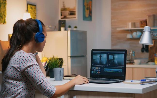 Una mujer edita un vídeo en un ordenador portátil.