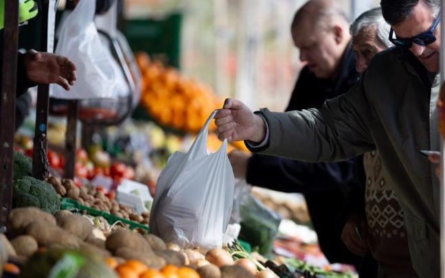 Varias personas compran en un mercado de alimentos