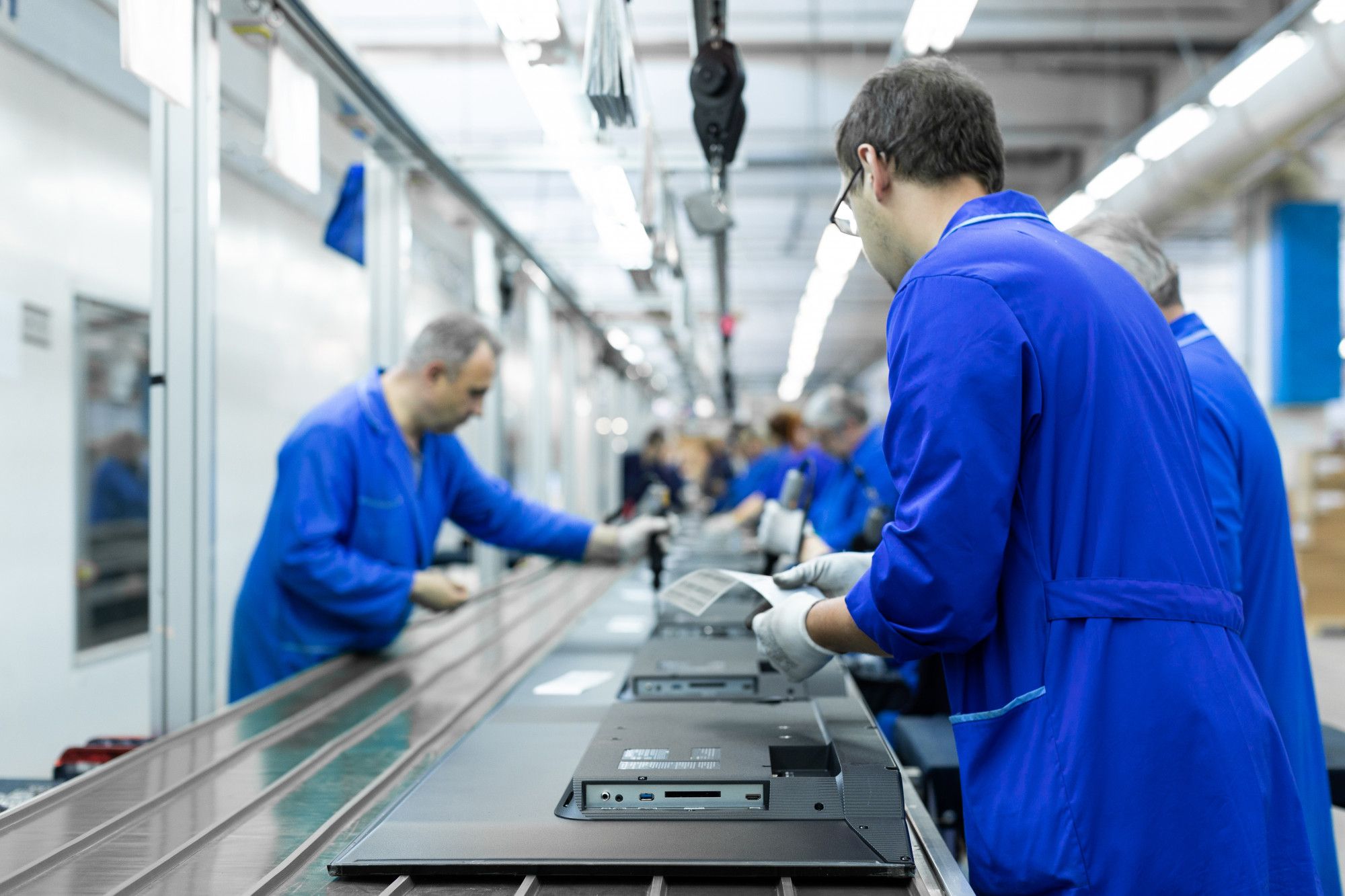 Trabajadores en un taller de montaje de televisores.