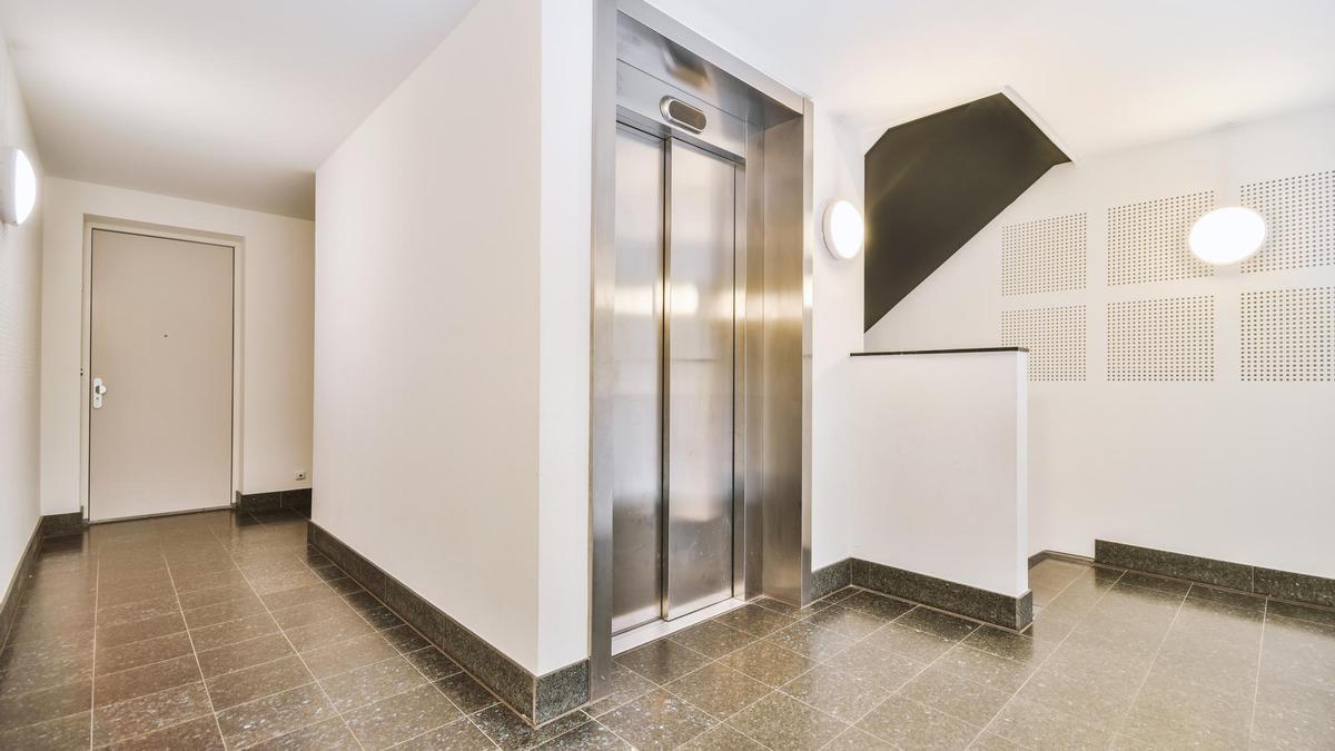 Ascensor junto a una vivienda en un bajo.