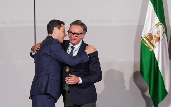 Moreno se abraza a Gavira en la imposición de medallas a los nuevos consejeros de la Junta de Andalucía.