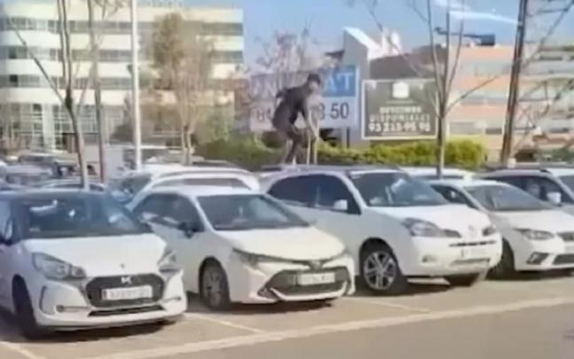 El joven, saltando sobre los coches.