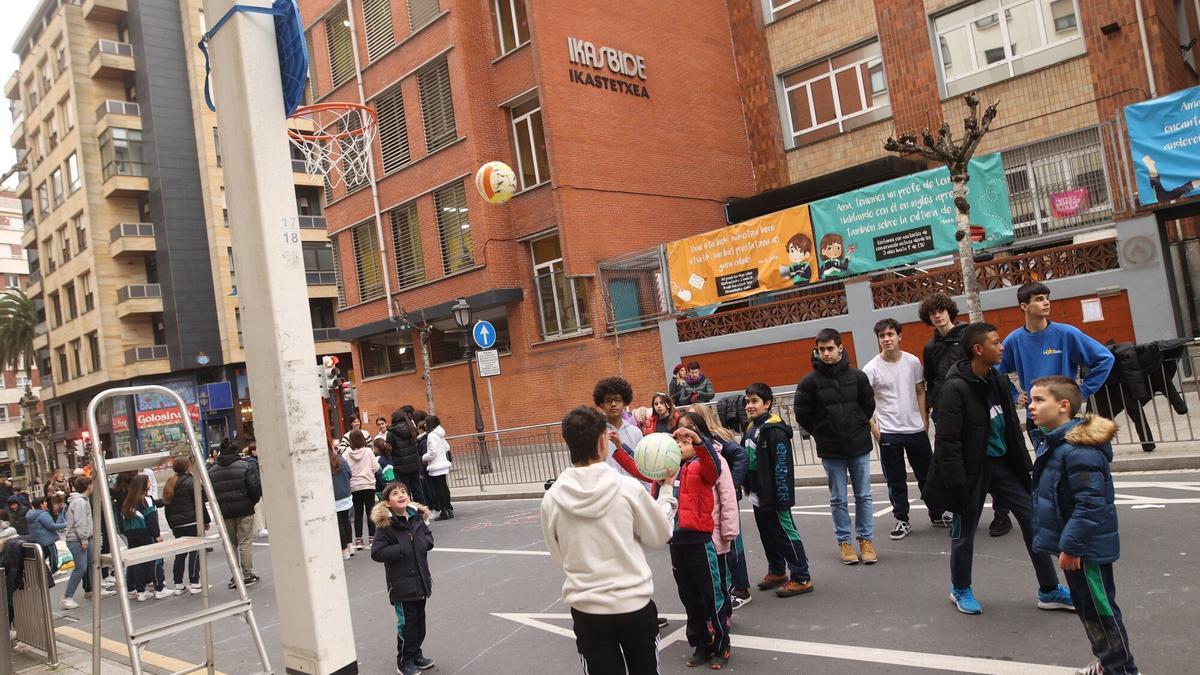 Jugando a baloncesto en el exterior del centro escolar.