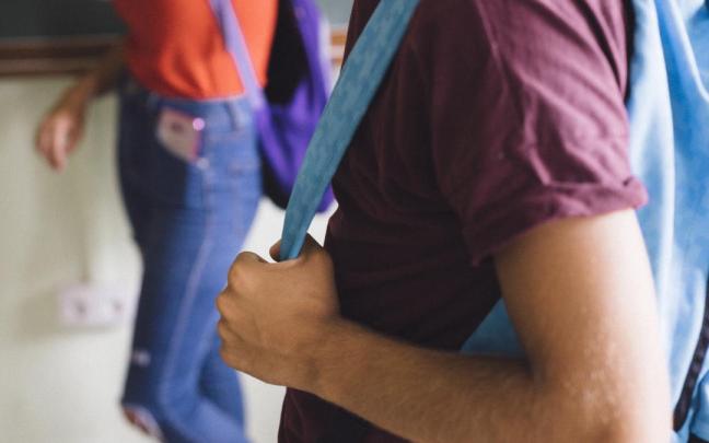 Estudiantes acuden al colegio con mochilas.