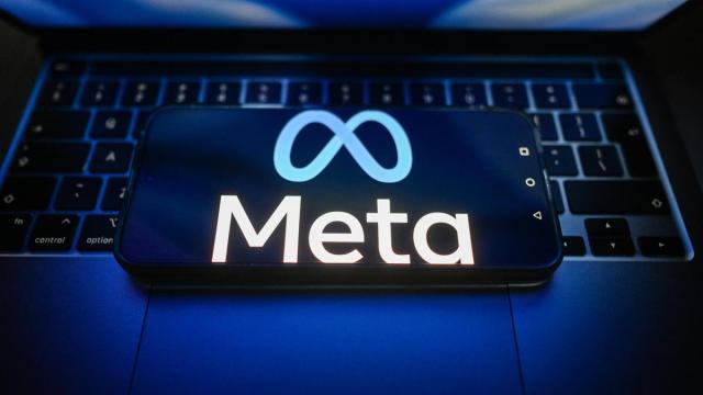 Logotipo de la empresa Meta en un teléfono móvil sobre el teclado de un ordenador portátil