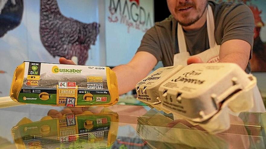 Un vendedor muestra cartones de huevos.