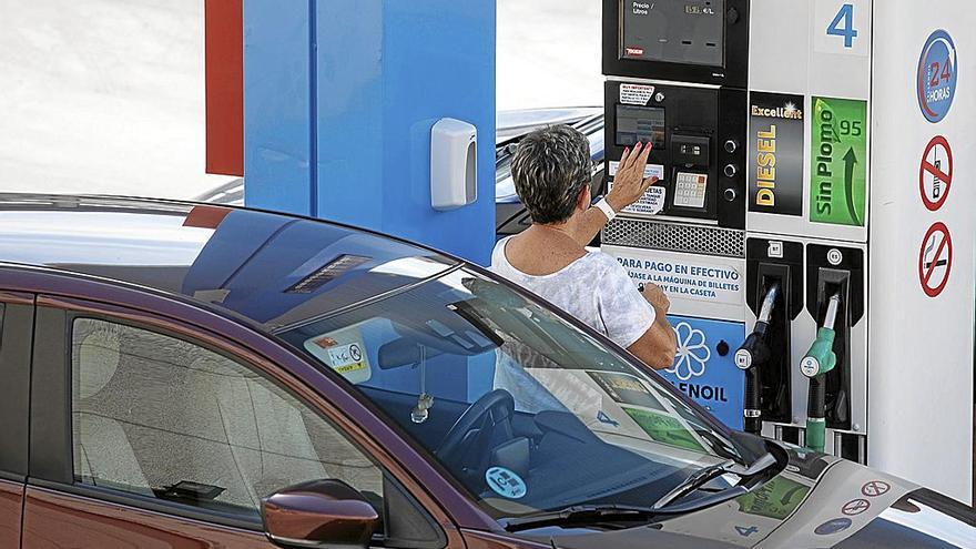 Una mujer se dispone a echar carburante a su vehículo en una estación de servicio.