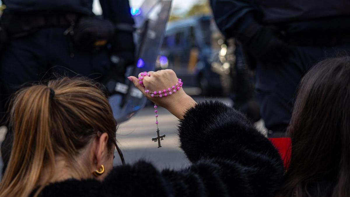 Una joven sostiene un rosario con la Cruz de la Victoria durante una manifestación en contra de la amnistía.