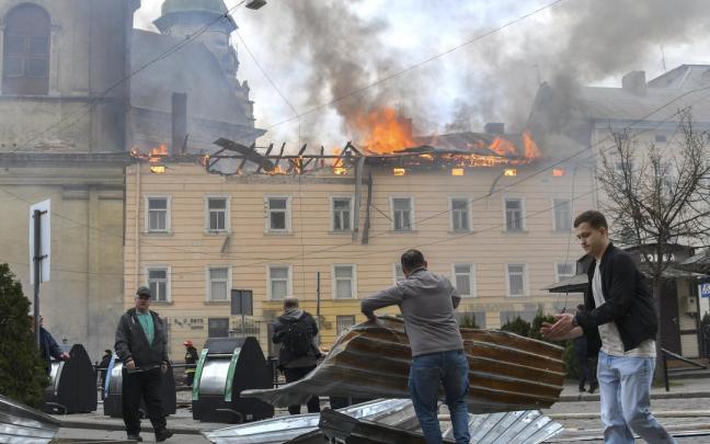 Unas personas retiran los escombros del lugar donde un dron ruso atacó el centro histórico de Leópolis, en el oeste de Ucrania