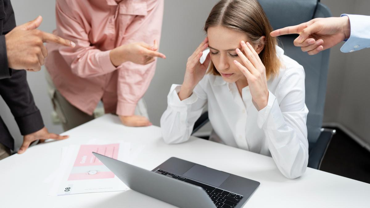 Una mujer subre mobbing en su entorno de trabajo