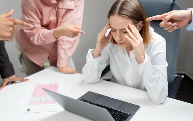 Una mujer subre mobbing en su entorno de trabajo