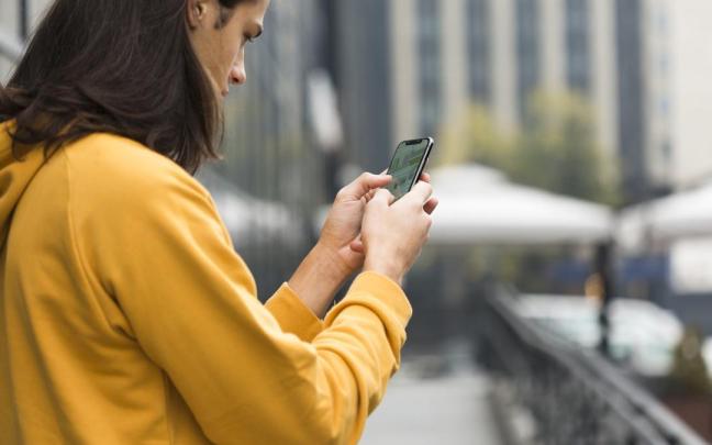 Un joven utiliza un teléfono móvil.