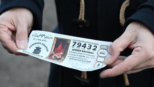 Un vecino de Villamanín muestra el décimo de El Gordo.