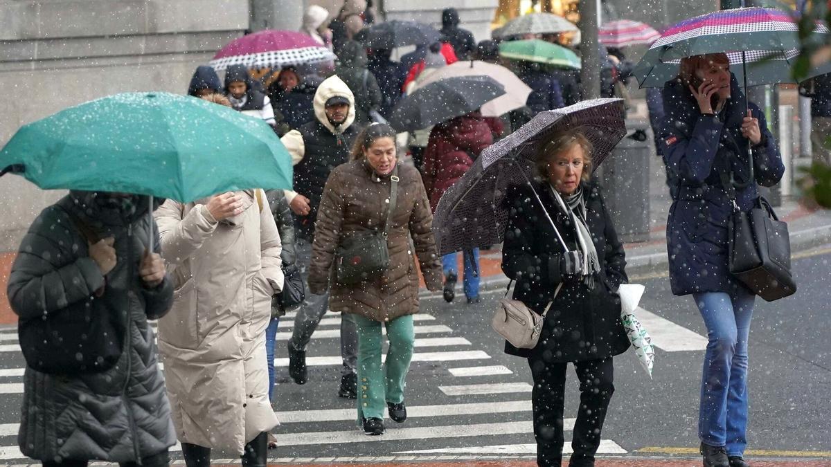 Viandantes, caminando por Bilbao bajo la nieve.