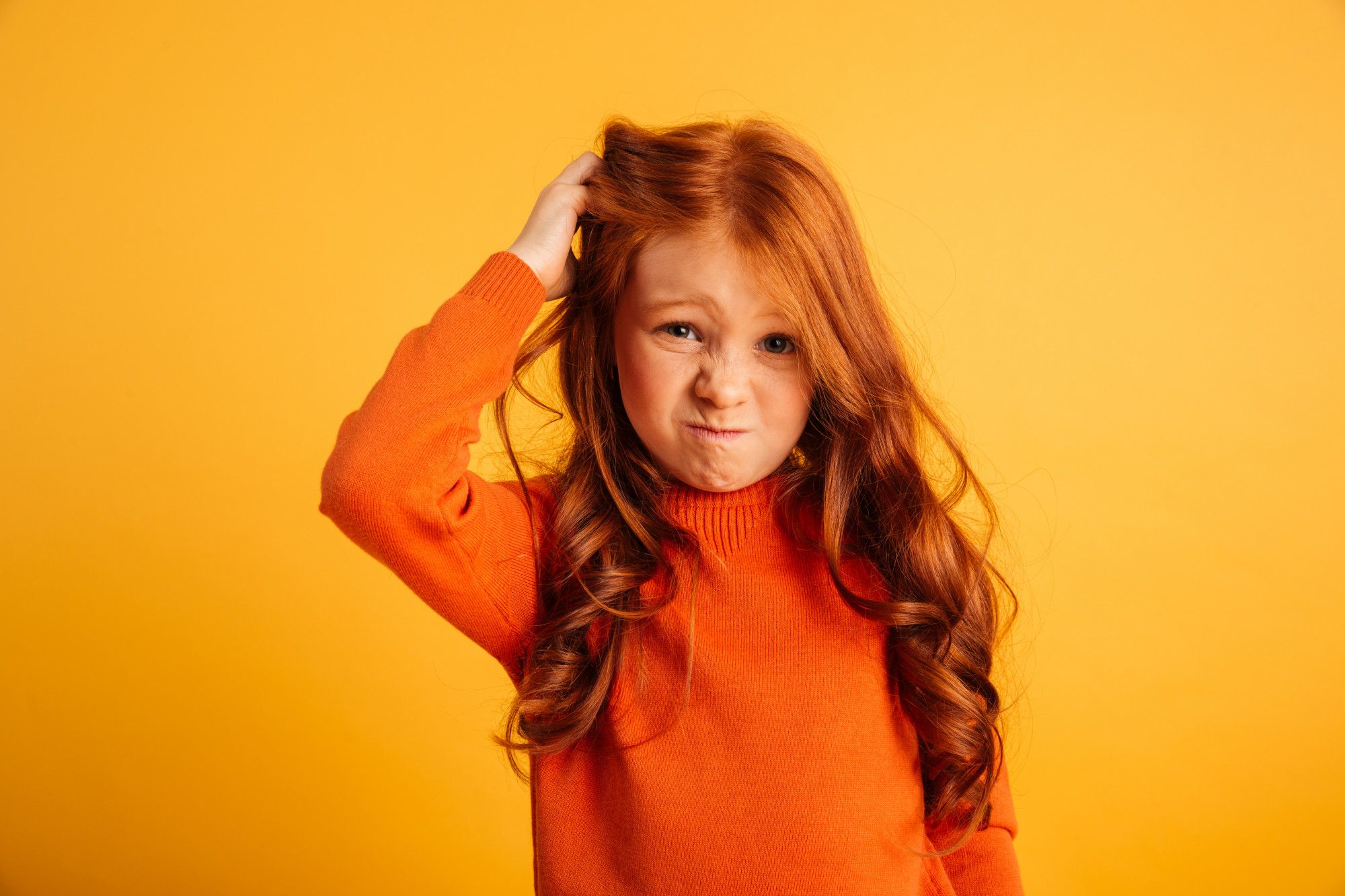 Una niña pelirroja con picor de cabeza.