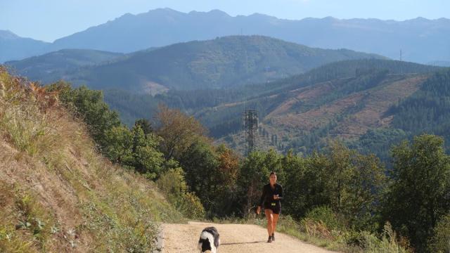 Una zumarragarra pasea por el monte Beloki con su perro.