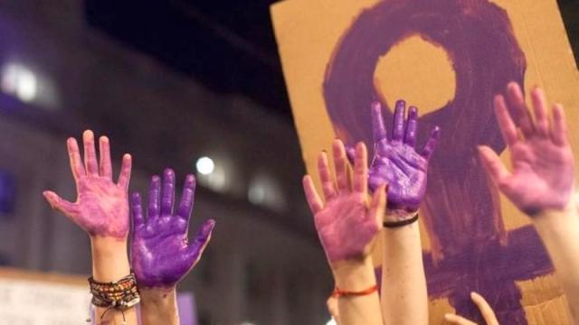 Imagen de archivo de manos pintadas de morado como defensa de las mujeres