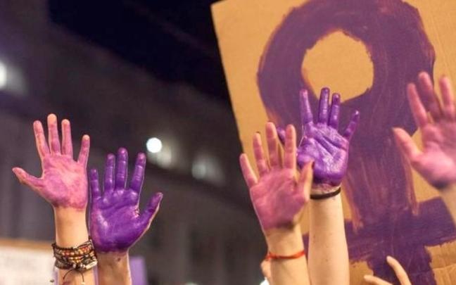Imagen de archivo de manos pintadas de morado como defensa de las mujeres