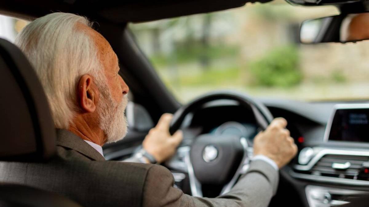 Señor mayor conduce un coche