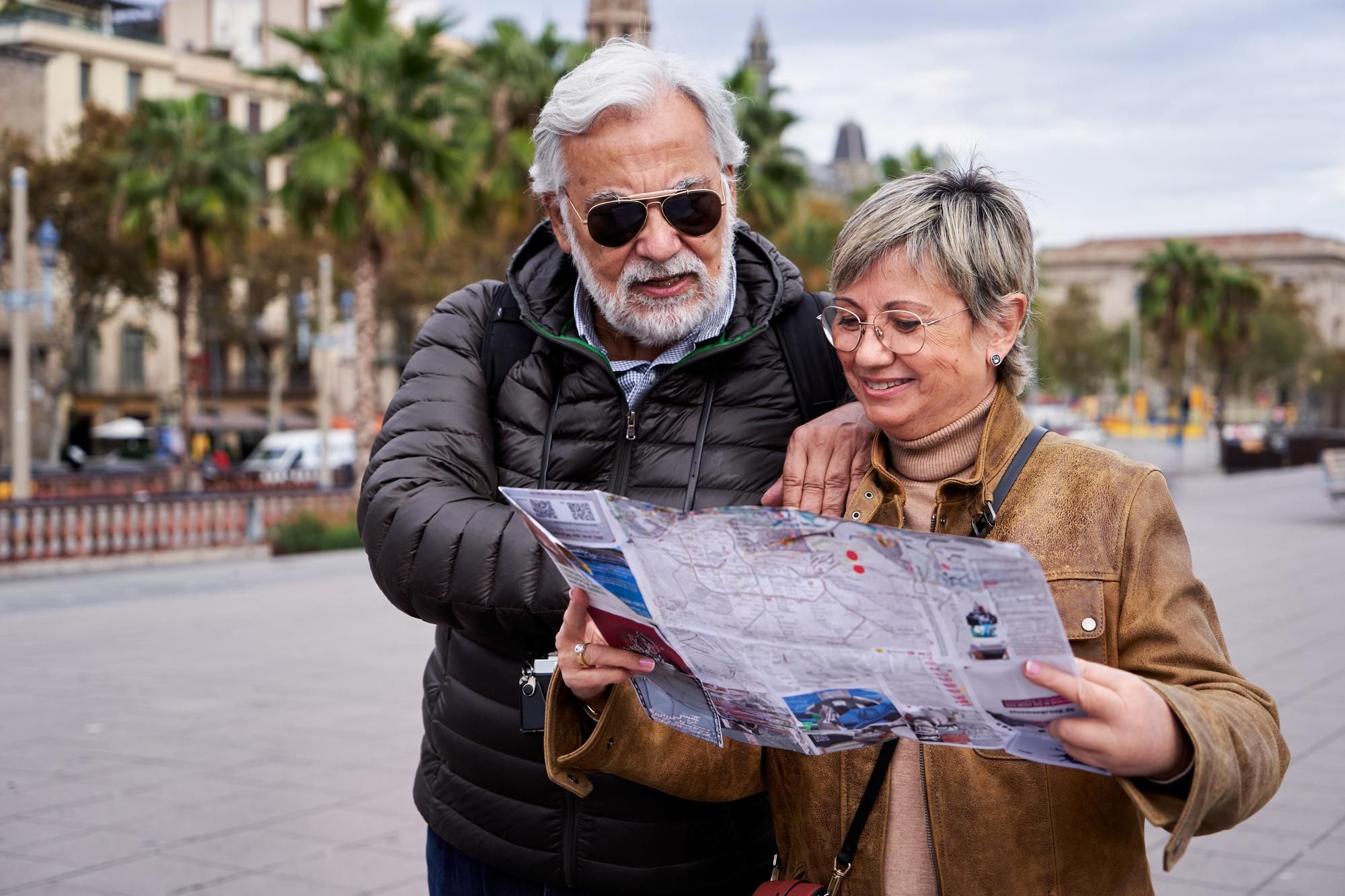 Una pareja de jubilados consulta un mapa durante un viaje.