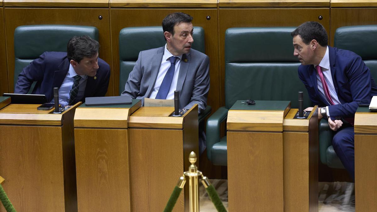 Imanol Pradales conversa con el Vicelehendakari y consejero de Economía Comercio y Empleo, Mikel Torres (c), en un pleno del Parlamento Vasco.